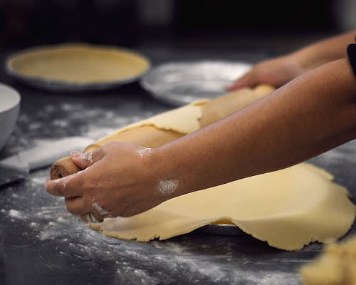 A Person Laying Dough into the Baking Pan