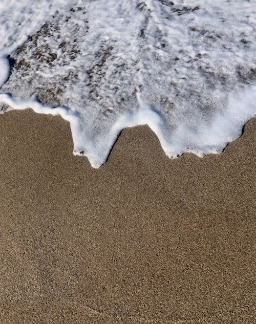 A Sea Foam Crashing on Sand