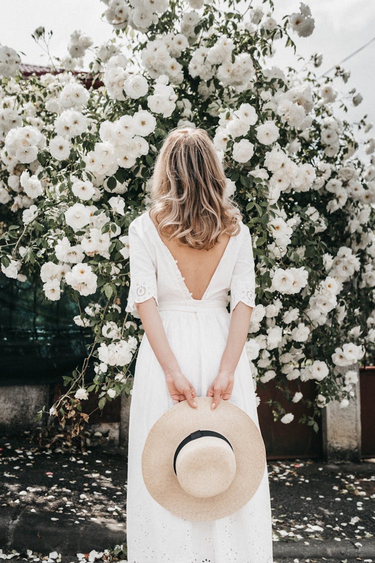 Woman In White Dress By Flowering Shrub