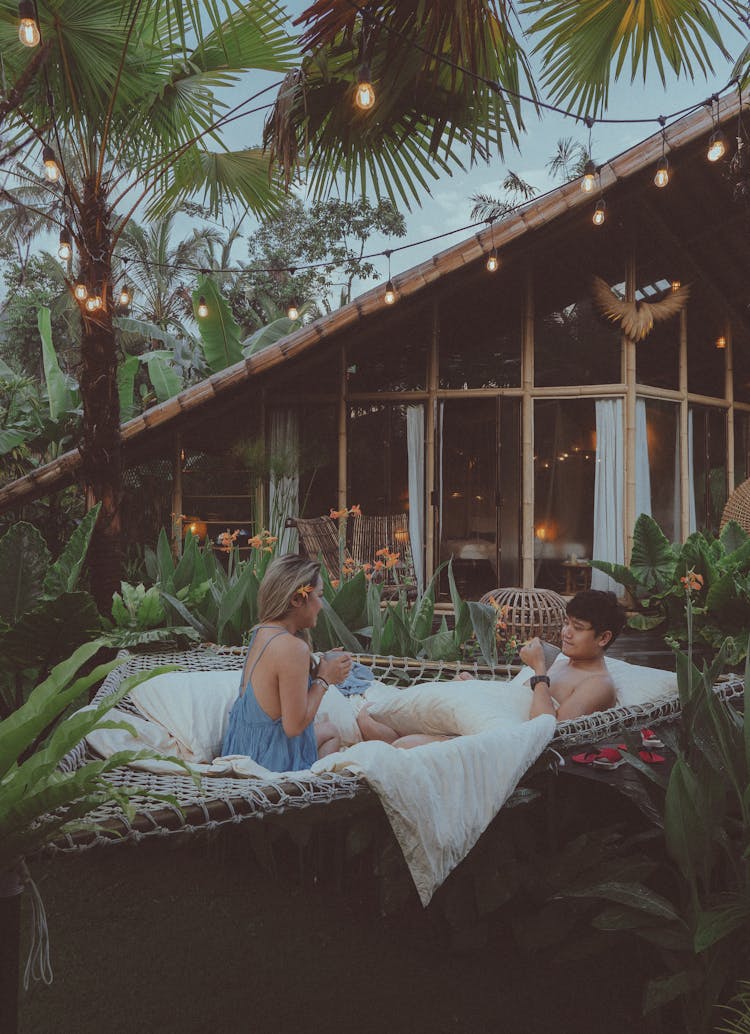 Woman And A Man In A Luxurious Resort With Bed In A Garden