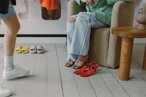 Free A stylish scene showcasing ripped jeans, vibrant shoes, and modern casual fashion indoors. Stock Photo