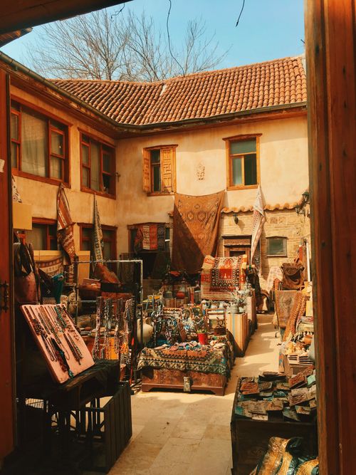 Free Explore a vibrant outdoor market in a rustic courtyard filled with handmade crafts and colorful textiles. Stock Photo