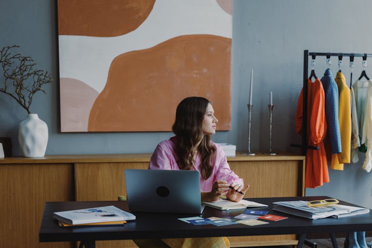 Woman Sitting At Table With Laptop And Books