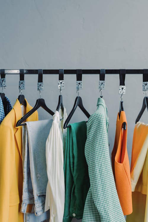 Free Assorted Clothes Hanging on Black Steel Rack Stock Photo