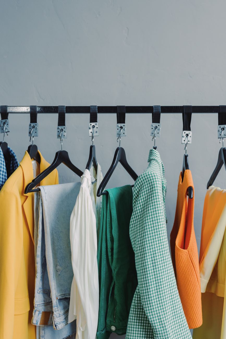 A vibrant display of assorted garments hanging on a clothing rack indoors.