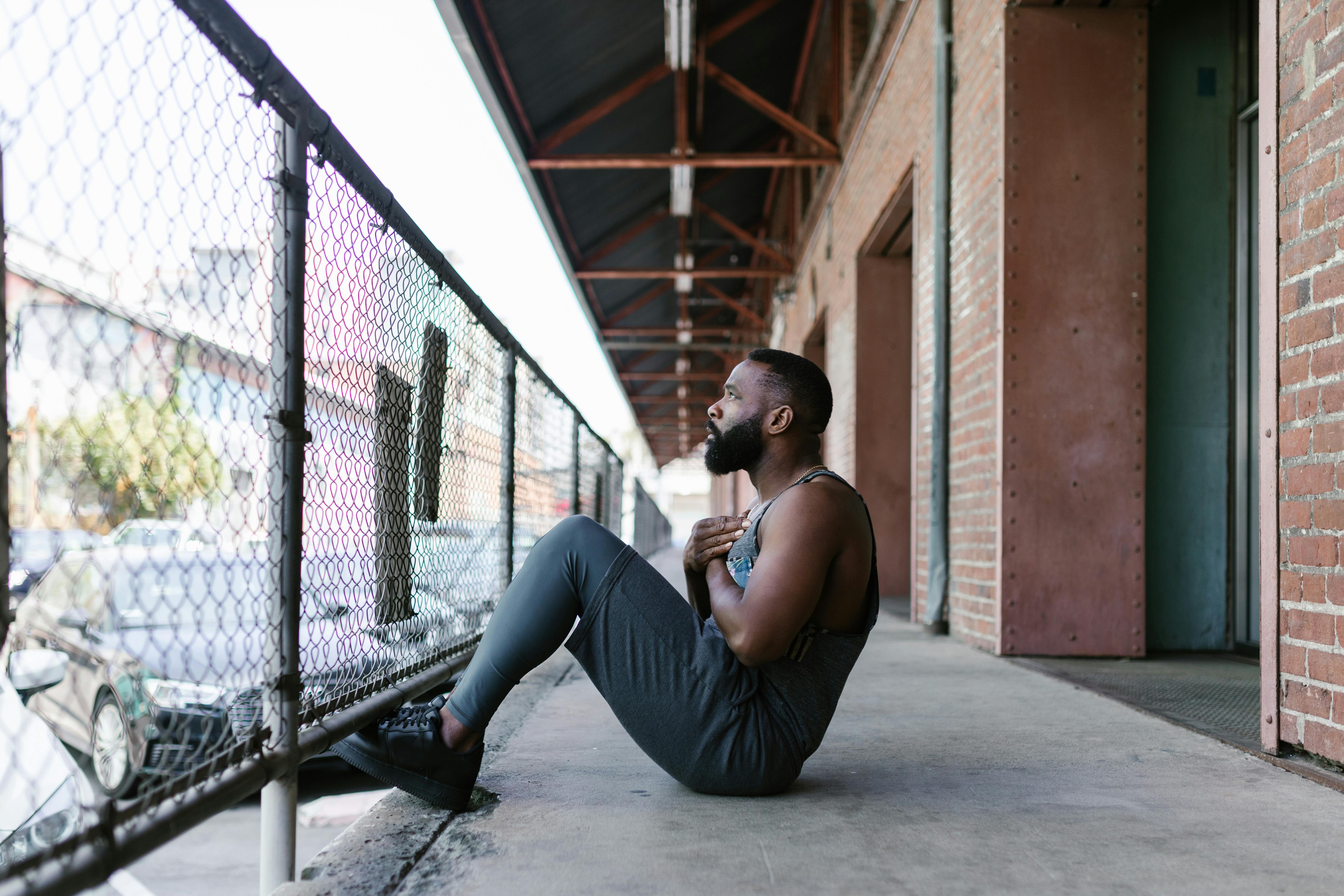 Athletic man performs an outdoor workout in an urban setting, showcasing strength and fitness.