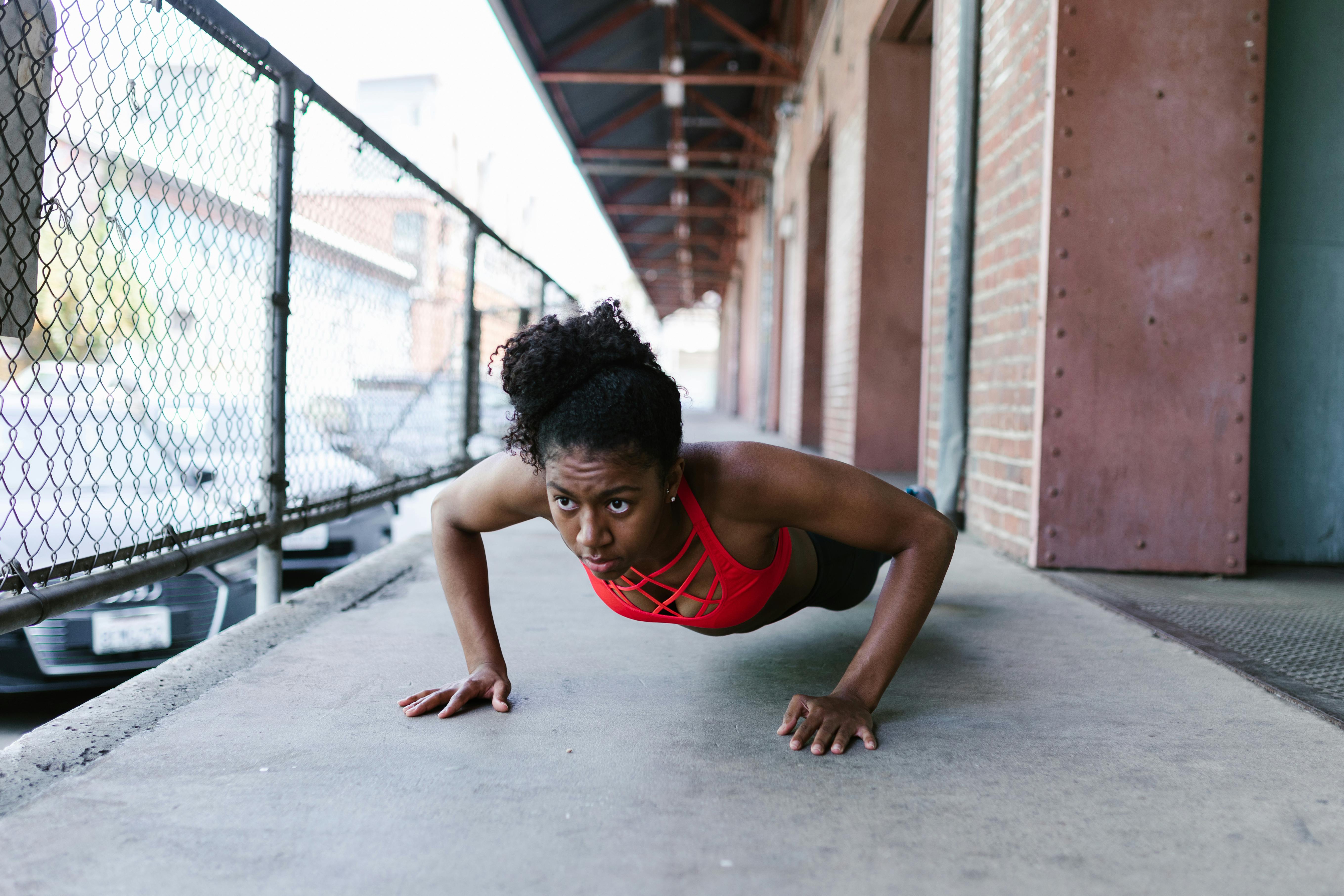 Premium Photo  Strong athletic black woman in a gym doing push-up  exercises in red sportswear