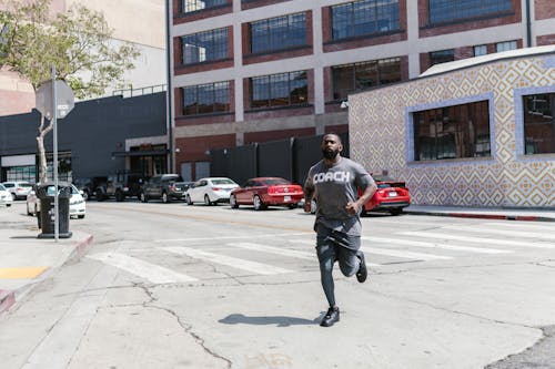 A Man in Activewear Jogging on the Street