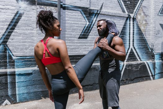 Man and woman in activewear during an outdoor fitness session, showcasing calisthenics.