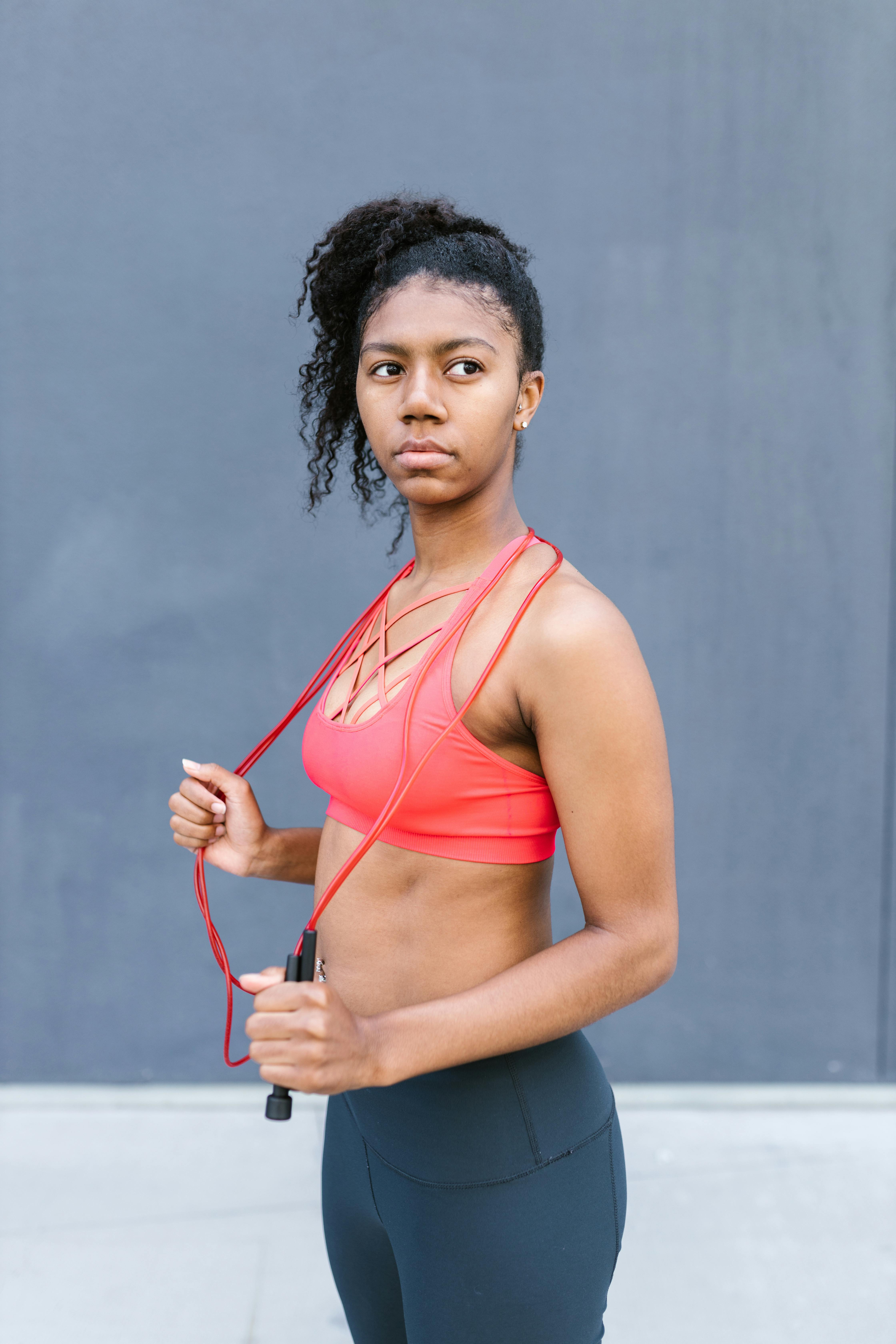 Woman Wearing Red Sports Bra Holding Skipping Ropes Smiling · Free