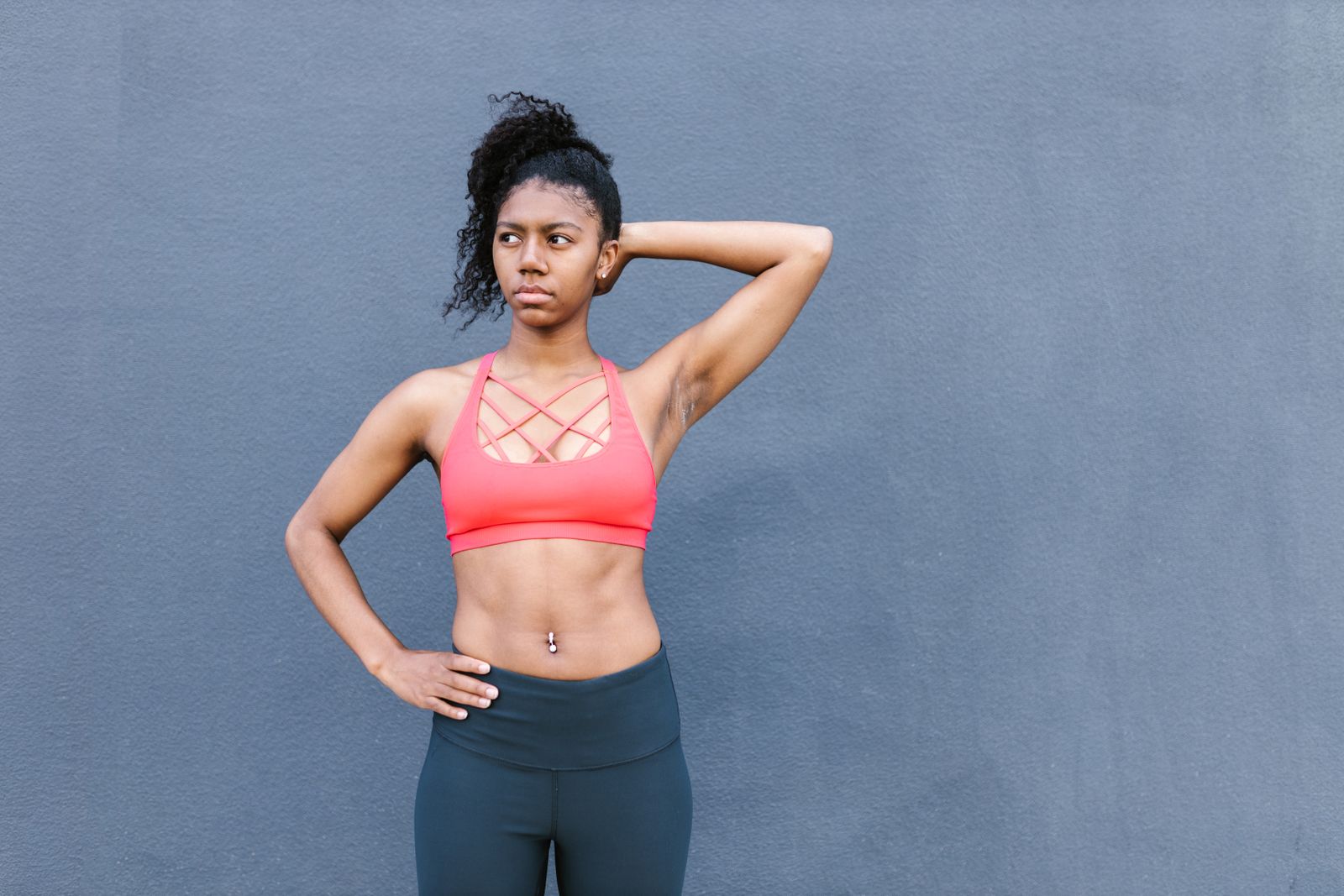 Athlete in the Draftline strap-back bra against a poured-concrete wall — photo by RDNE Stock project on Pexels