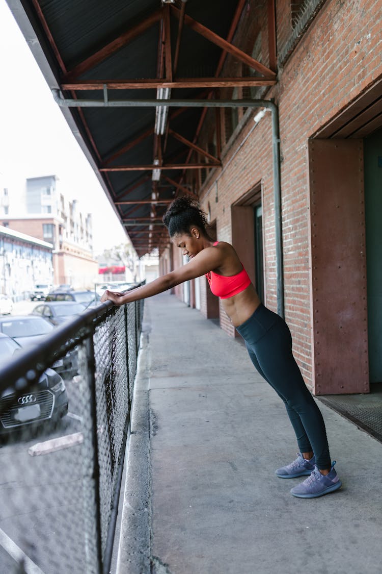 A Woman In Red Tank Top Doing An Exercise