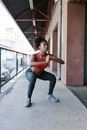 Woman in Red Sports Bra Squatting