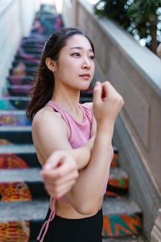 Woman in activewear stretches on vibrant staircase, promoting fitness.
