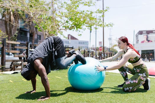 Two people exercising outdoors with a fitness ball, promoting strength and balance.