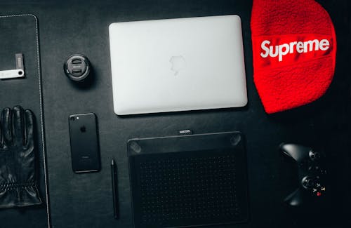 Free Macbook Beside Red Supreme Textile Stock Photo