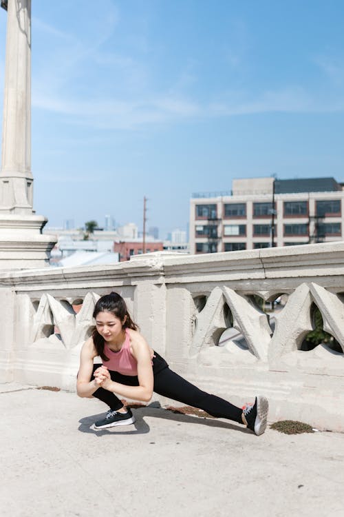 A Woman in Pink Tank Top Stretching