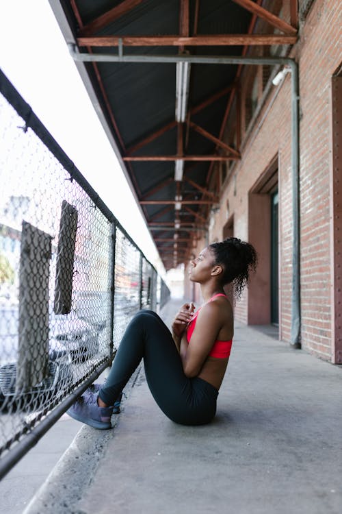 Photos gratuites de brassière de sport, cheveux afro, clôture métallique