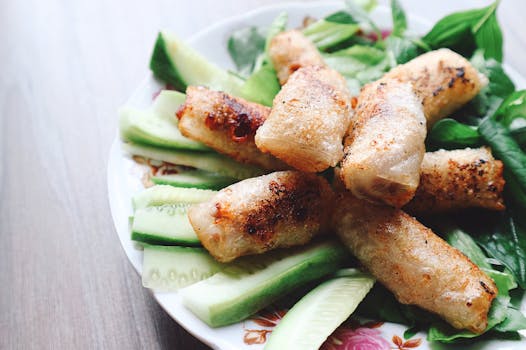 盘子里放着脆皮春卷，配着新鲜黄瓜和香草