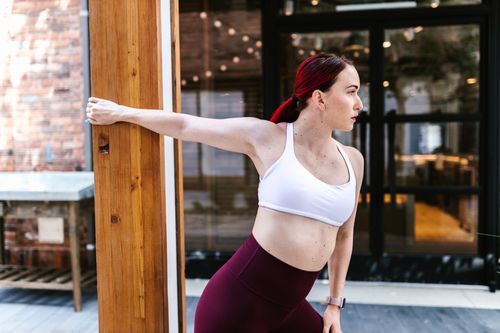 Free A woman in activewear stretches outdoors, showcasing a fit and healthy lifestyle. Stock Photo