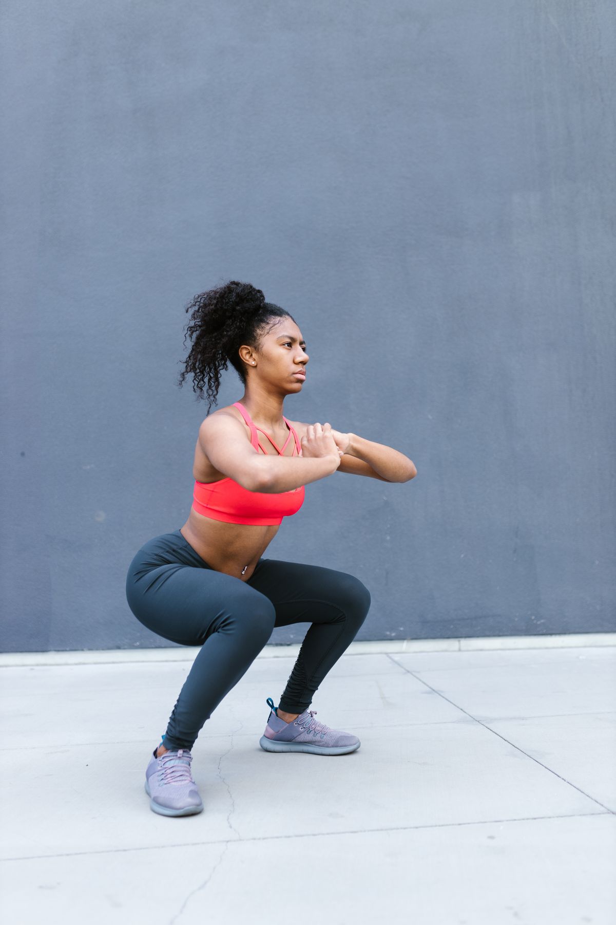 Fit woman executing a squat exercise outdoors