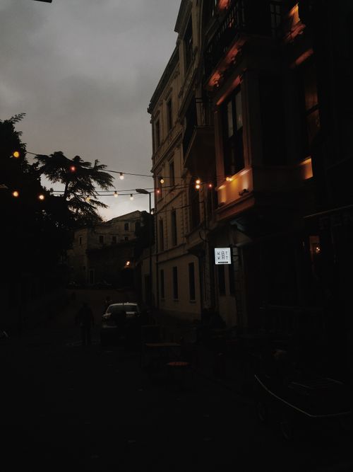 Free A dimly lit street in Istanbul, Turkey, adorned with string lights and historic buildings, creating a cozy night scene. Stock Photo