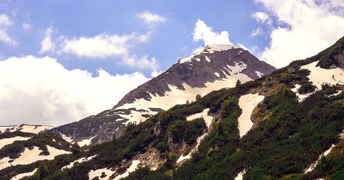 Stunning view of snow-covered mountains in Pirin National Park, Bulgaria under a clear blue sky.