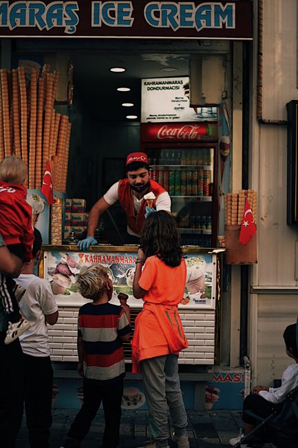 Kahramanmaraş ice cream vendor serving customers on a lively street in Istanbul, Türkiye.
