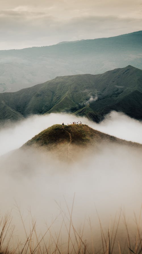 Brown and Green Mountain Covered With Clouds