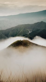 Serene view of mist-covered mountains with peaks and clouds, ideal for nature enthusiasts.