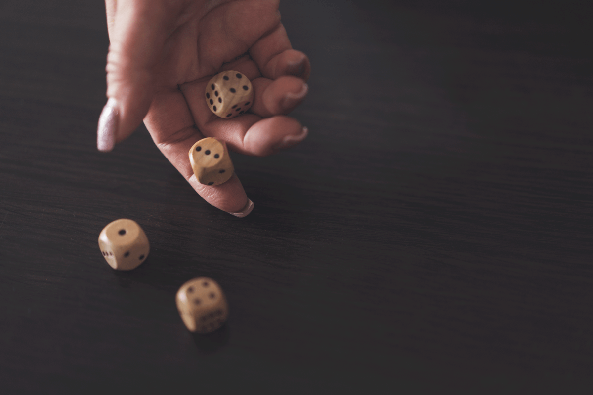 Close-up of a hand rolling wooden dice