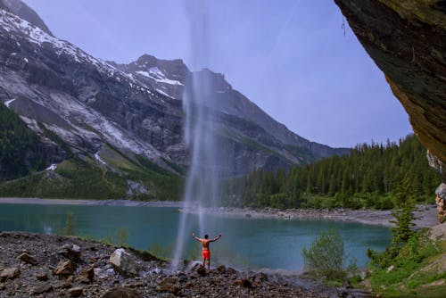 Person Standing Under a Waterfalls