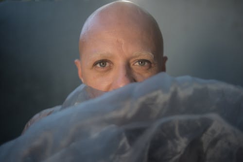 Free Close-Up Photo of a Bald Man with Beautiful Eyes Looking at the Camera Stock Photo