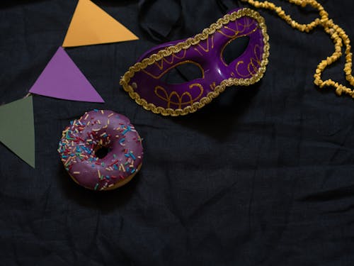 A Festival Mask and a Donut on the Black Fabric