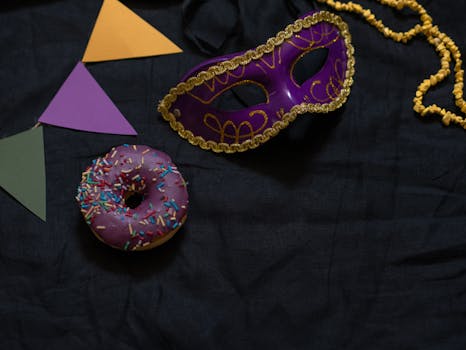 Colorful Mardi Gras mask with sprinkles donut and festive decor.
