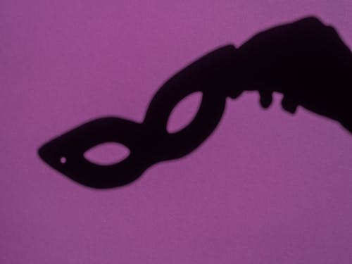 Free Shadow of Person's Hand Holding Masquerade Mask  Stock Photo