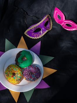 Vibrant Mardi Gras setting featuring colorful donuts and masks on a black background.