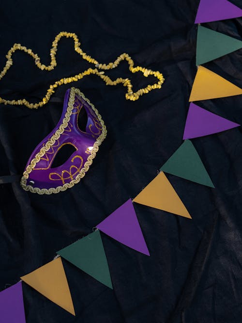 Free Purple Mask Beside Yellow Accessory and Banderitas on a Black Surface Stock Photo