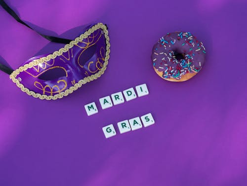 Mask and Donut With Scrabble Tiles On Purple Background