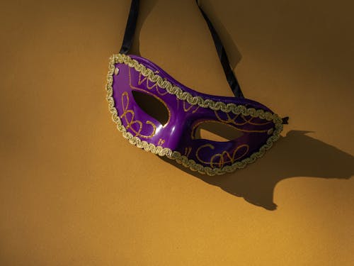 Close-Up Shot of a Purple Mask on a Yellow Surface