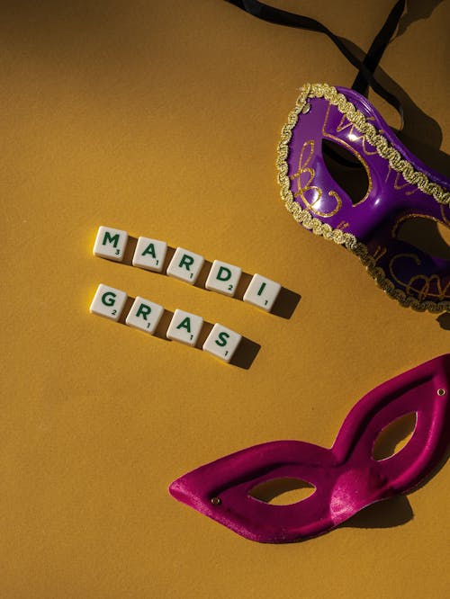 Close-Up Shot of Carnival Masks on a Yellow Surface