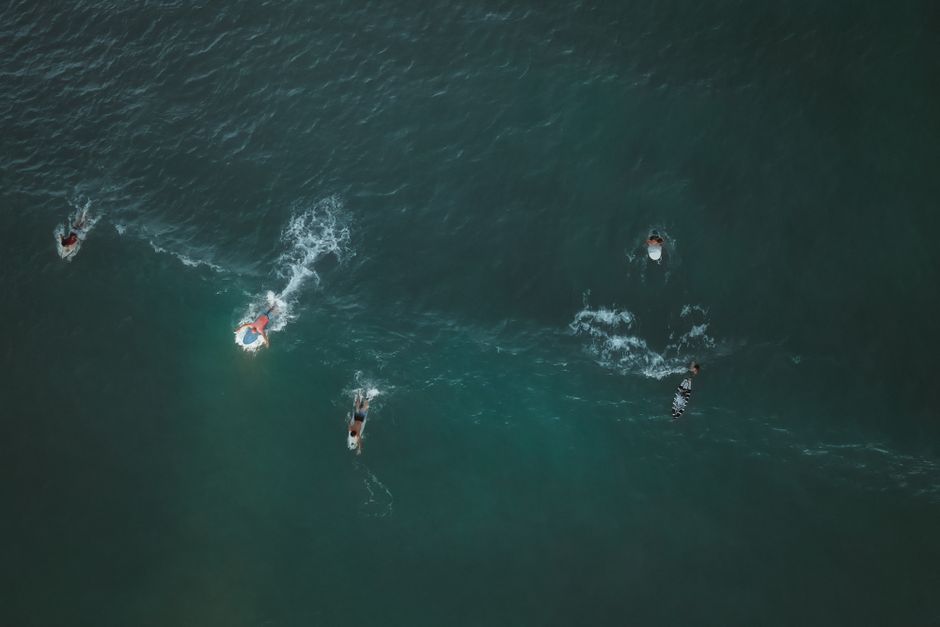 Aerial shot of surfers paddling in the ocean, Terengganu, Malaysia. Vibrant outdoor water sports scene.
