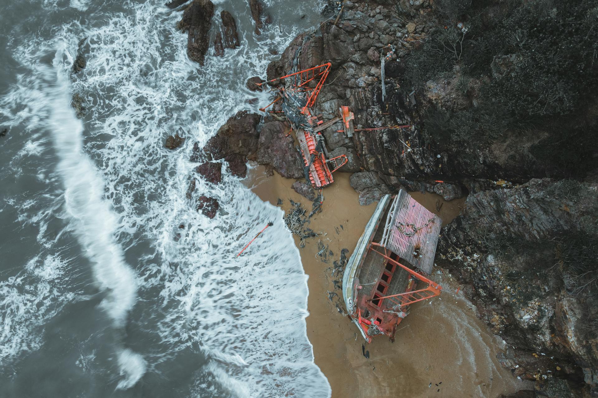 A stunning aerial view of a shipwreck along the rocky shoreline of Chukai, Terengganu, Malaysia.