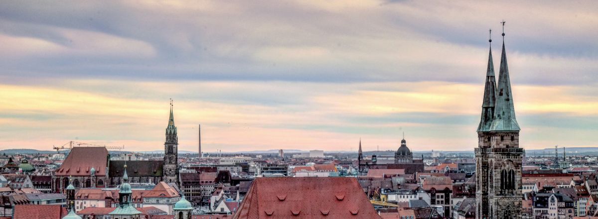 A stunning view of Nuremberg's historic skyline with iconic church towers and a vibrant sky.