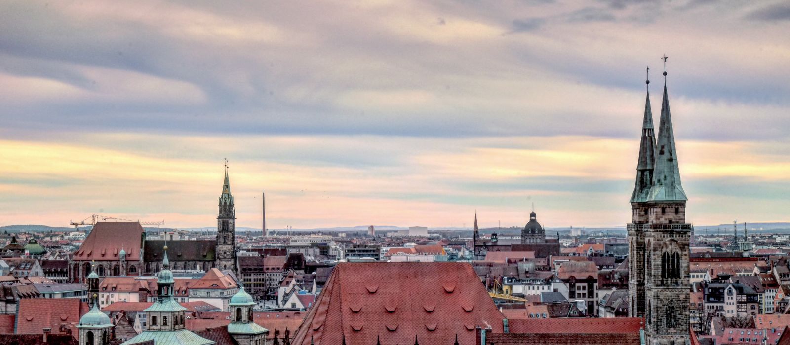 A stunning view of Nuremberg's historic skyline with iconic church towers and a vibrant sky. — flights from Palma to Nuremberg