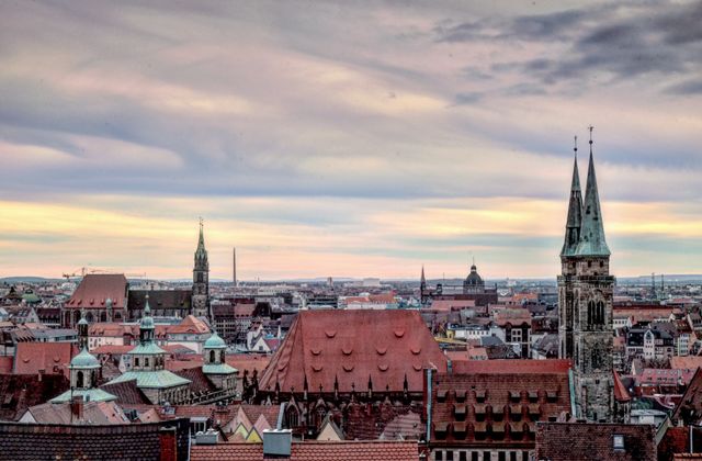 A stunning view of Nuremberg's historic skyline with iconic church towers and a vibrant sky. — arriving in Nuremberg