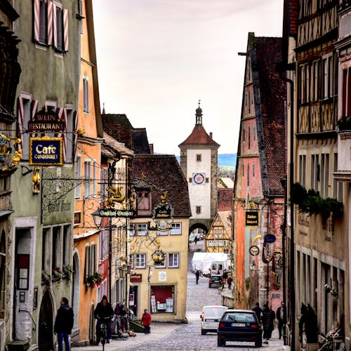 People and Cars Between Historical Buildings