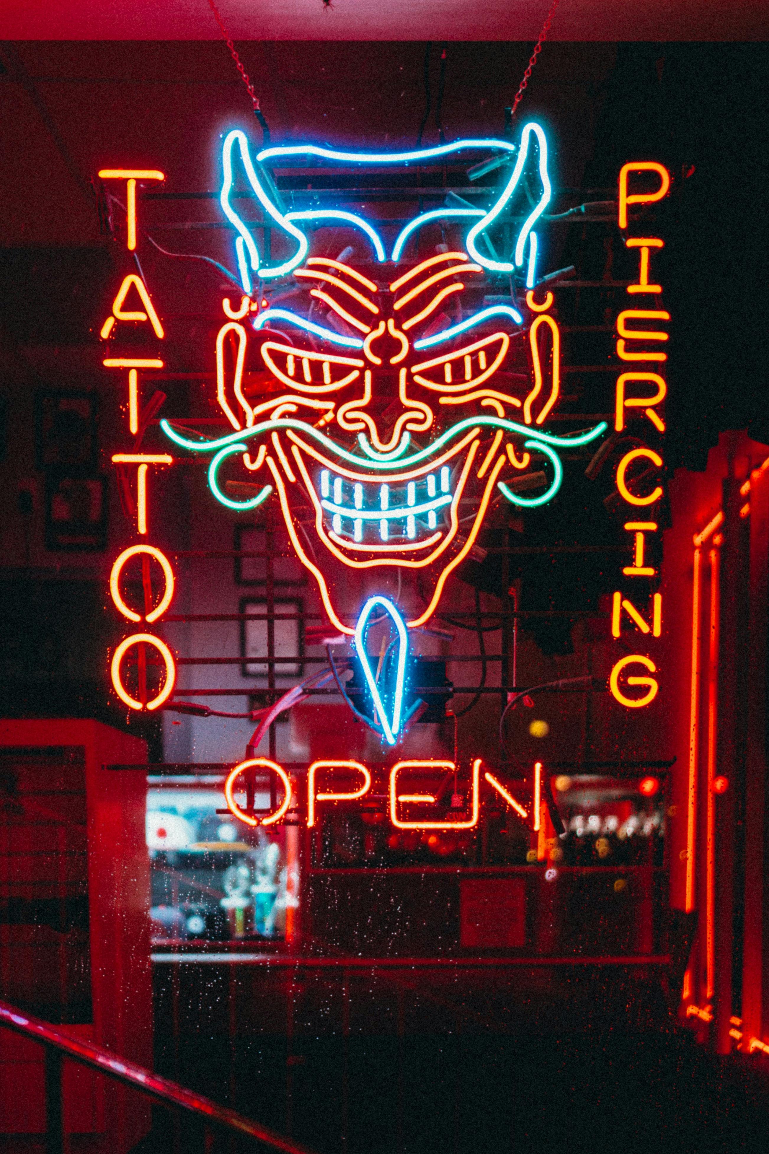 Tattoo and Piercing Neon Sign at Night  Free Stock Photo