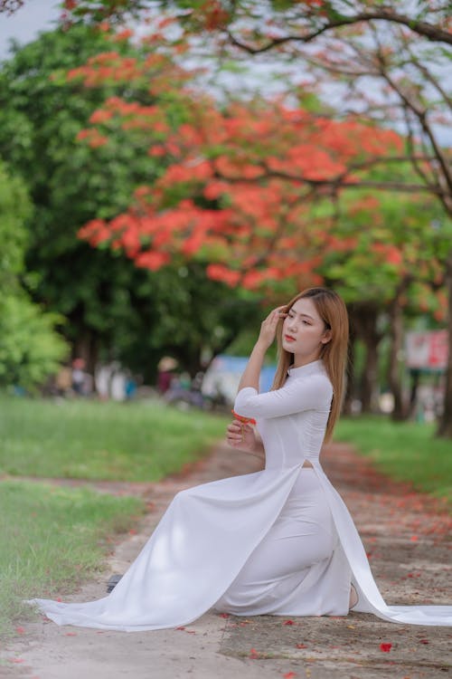A Woman Posing while Wearing a White Ao Dai
