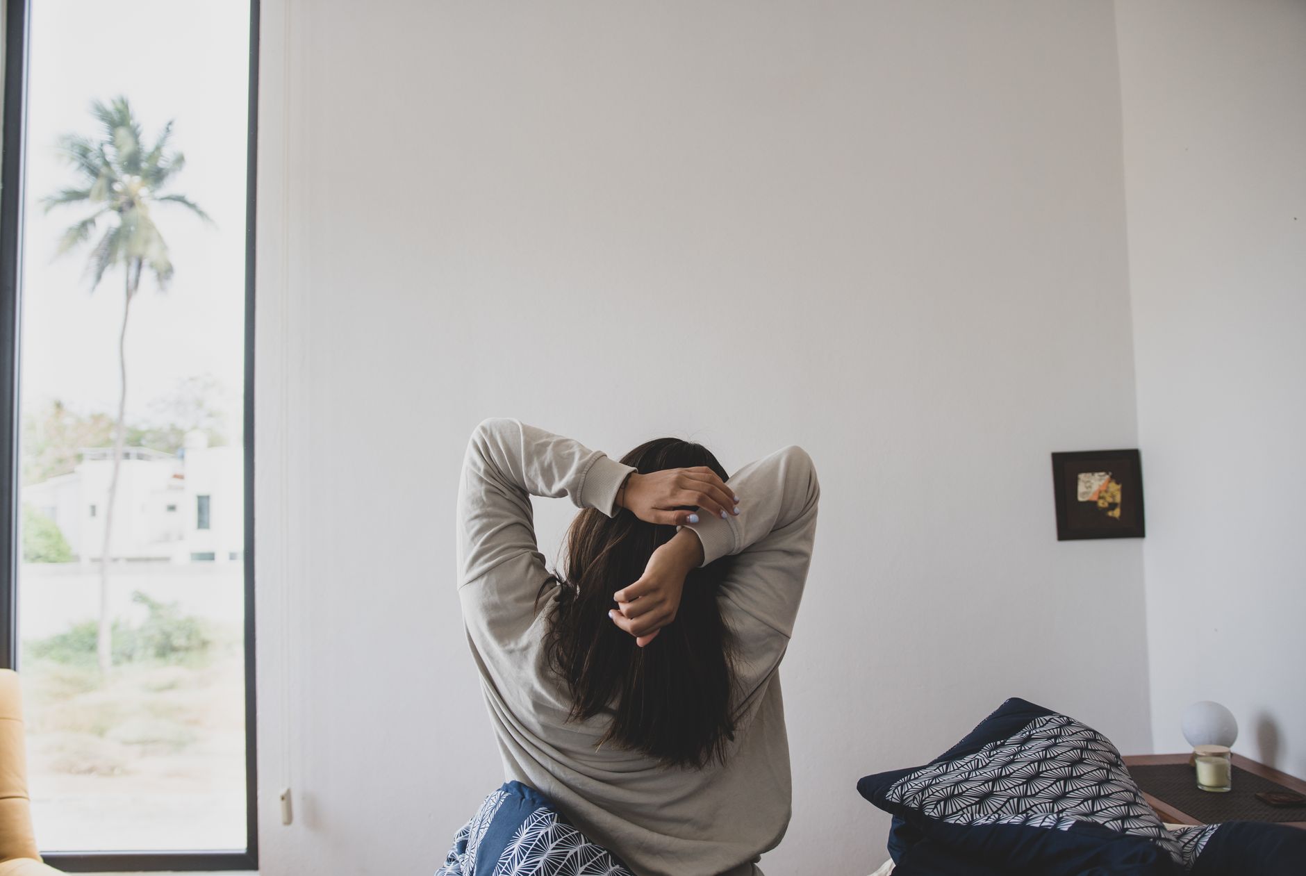 Indian professional practicing yoga on a rooftop at sunrise with a calm, focused expression